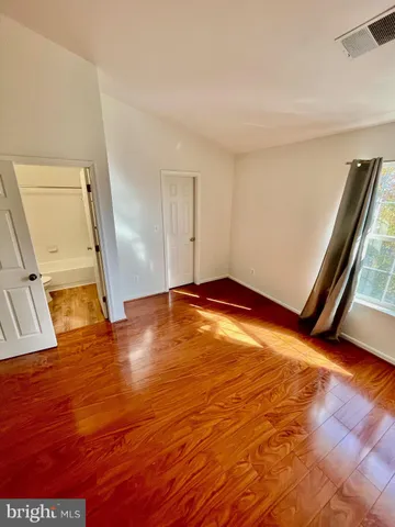 a view of empty room with wooden floor