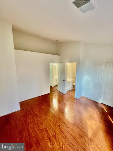a view of empty room with wooden floor