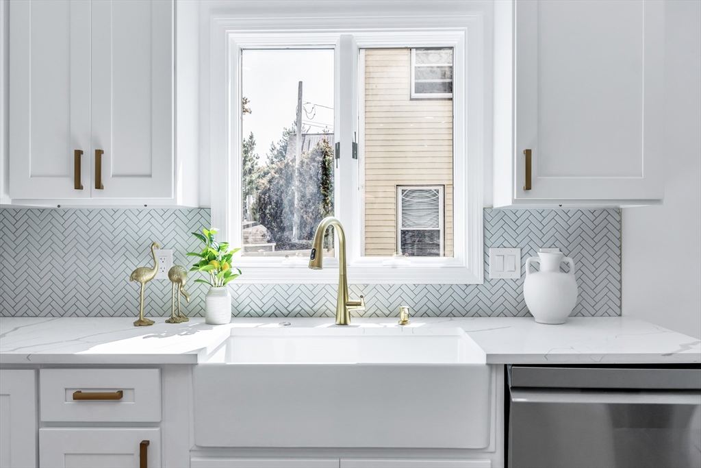 24 Ballard Street Saugus, MA 01906 - Photo 3 of 38 a bathroom with a granite countertop sink a potted plant and windows