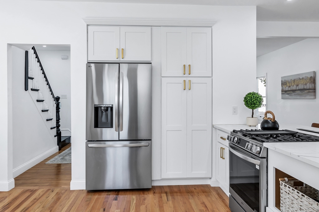 24 Ballard Street Saugus, MA 01906 - Photo 7 of 38 a kitchen with a refrigerator a stove and wooden floor