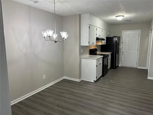 a view of a kitchen with a sink wooden floor and a refrigerator