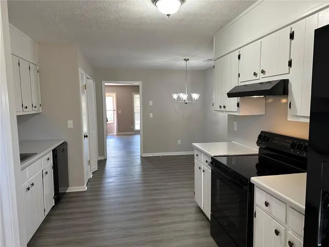 a kitchen with granite countertop a stove and a refrigerator