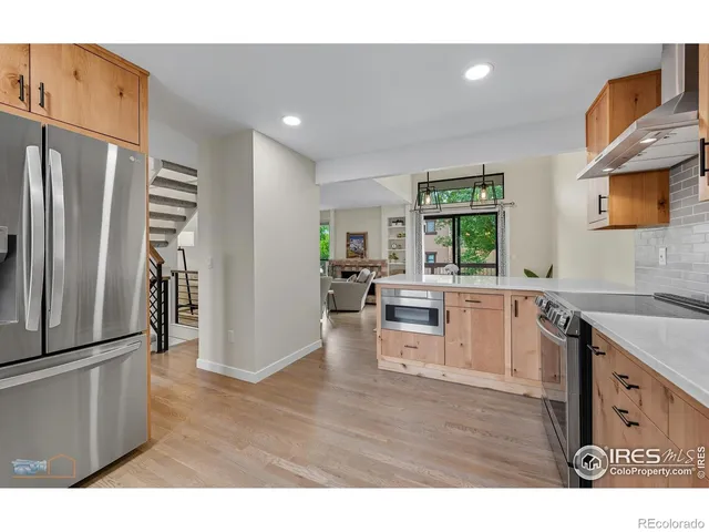 a kitchen with stainless steel appliances granite countertop a refrigerator a stove a sink and a refrigerator