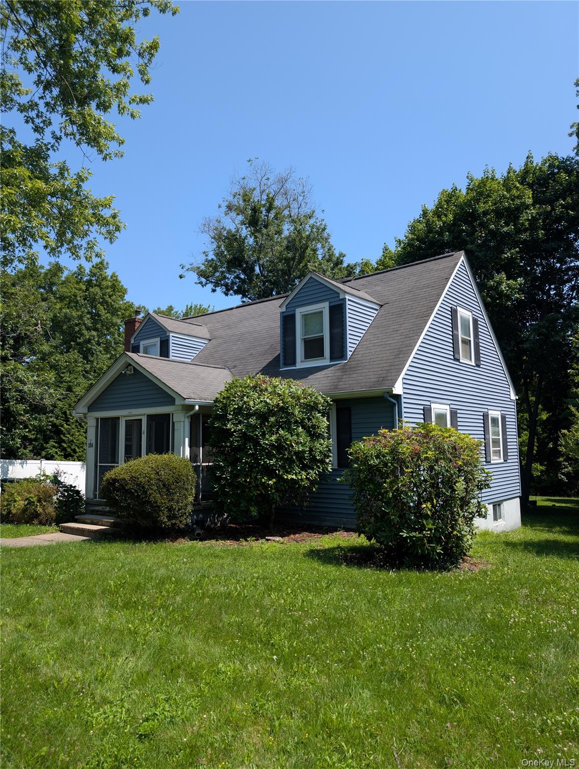 394 Riley Road, Unit 1 New Windsor, NY 12553 - Photo 2 of 24 Located in a Cape Cod with blue siding and dormer windows, enter through a screened porch.