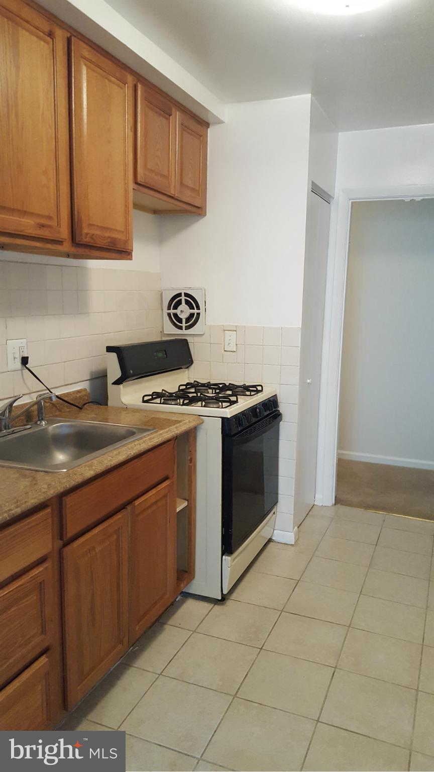 3845 St Barnabas Road, Unit T Suitland, MD 20746 - Photo 2 of 8 a kitchen with stainless steel appliances granite countertop a stove and a sink