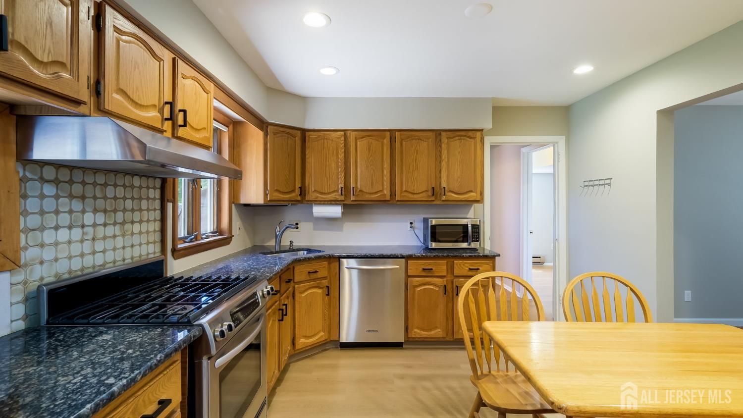 50 Sand Hills Road Kendall Park, NJ 08824 - Photo 9 of 27 a kitchen with stainless steel appliances granite countertop a stove a sink and a microwave