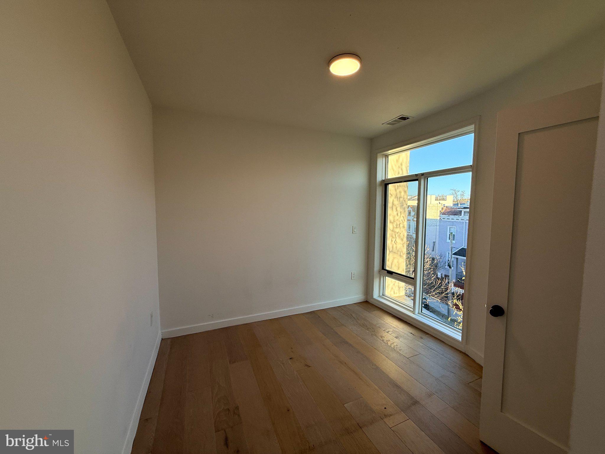 3601 14th Street Northwest, Unit 6 Washington, DC 20010 - Photo 15 of 26 an empty room with wooden floor and windows