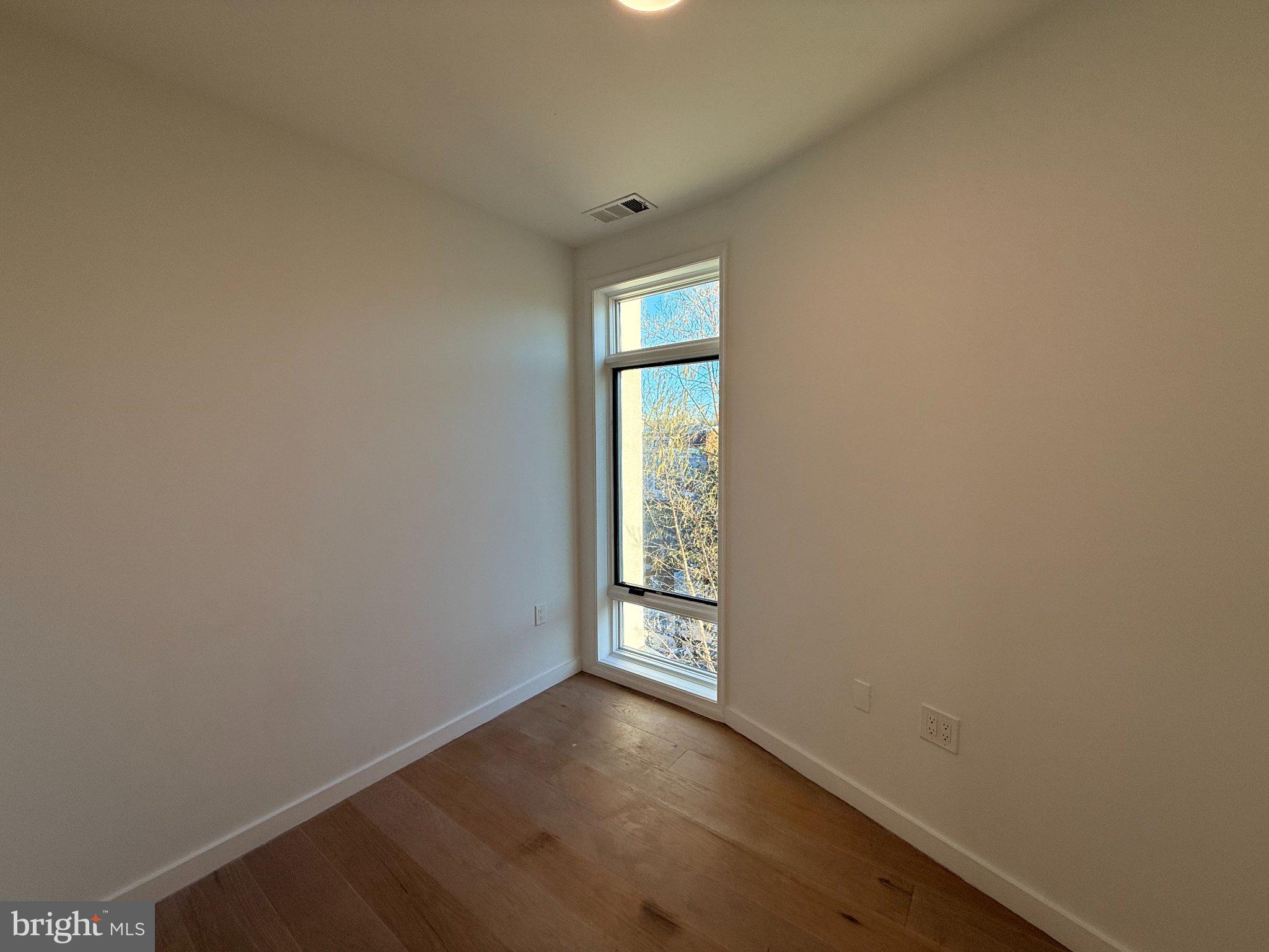 3601 14th Street Northwest, Unit 6 Washington, DC 20010 - Photo 10 of 26 a view of an empty room with wooden floor and a window