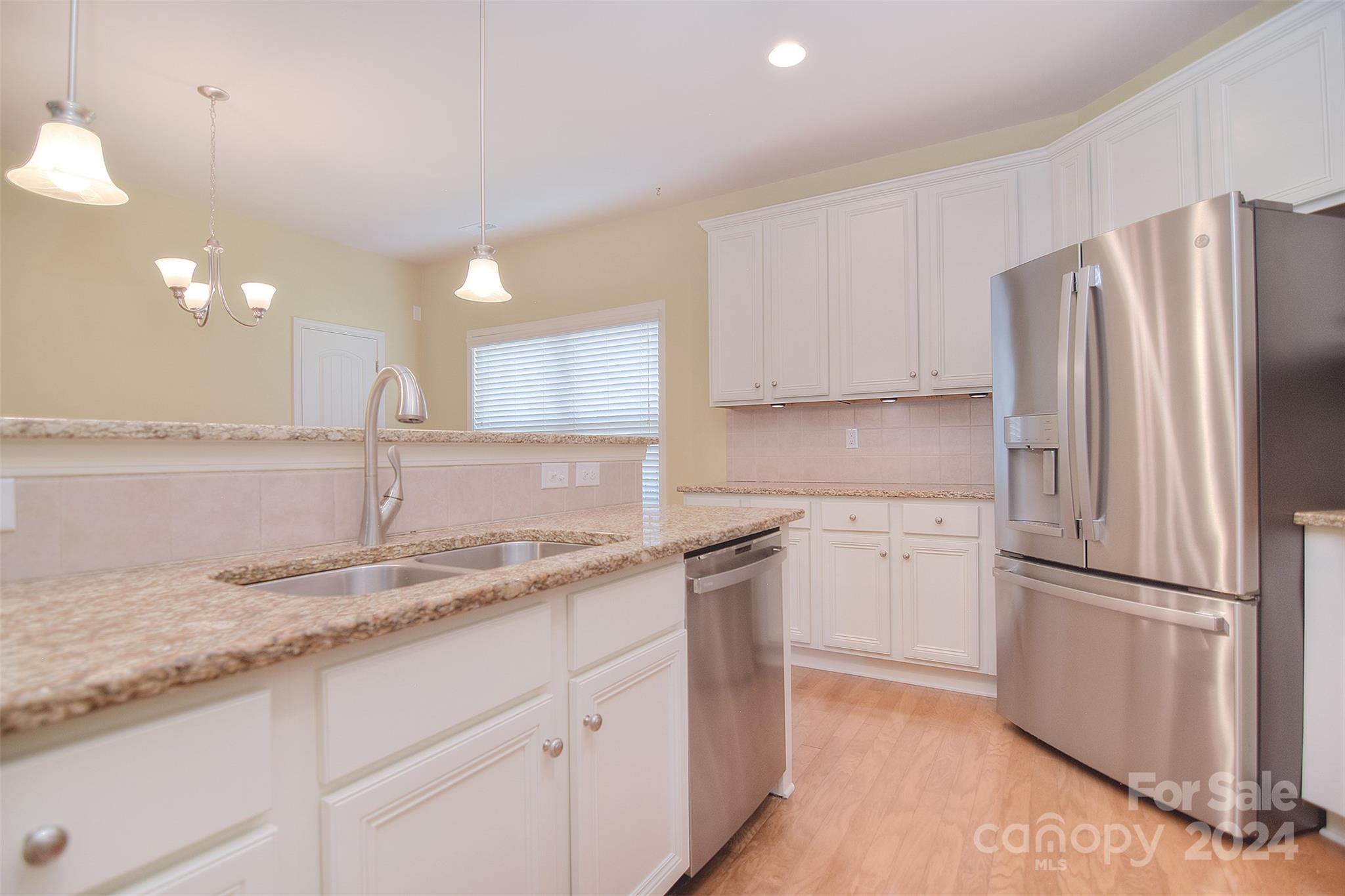 7004 Sedgewick Road Indian Trail, NC 28079 - Photo 11 of 38 a kitchen with kitchen island granite countertop appliances cabinets and a sink