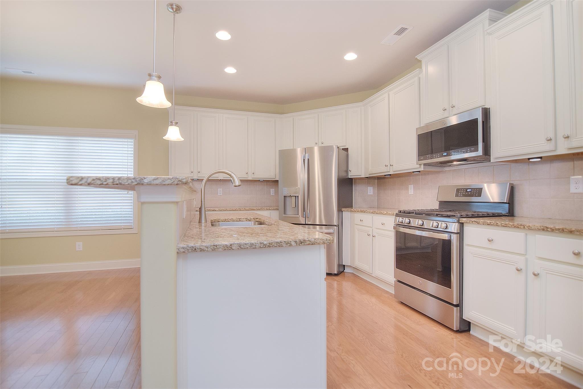 7004 Sedgewick Road Indian Trail, NC 28079 - Photo 8 of 38 a kitchen with stainless steel appliances granite countertop a stove a sink and a refrigerator
