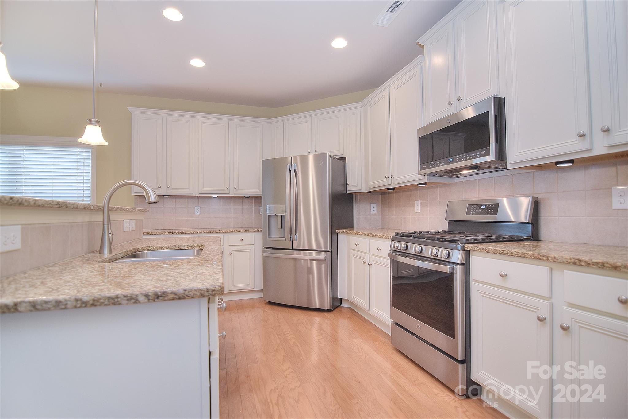 7004 Sedgewick Road Indian Trail, NC 28079 - Photo 9 of 38 a kitchen with stainless steel appliances granite countertop a stove a sink and a refrigerator