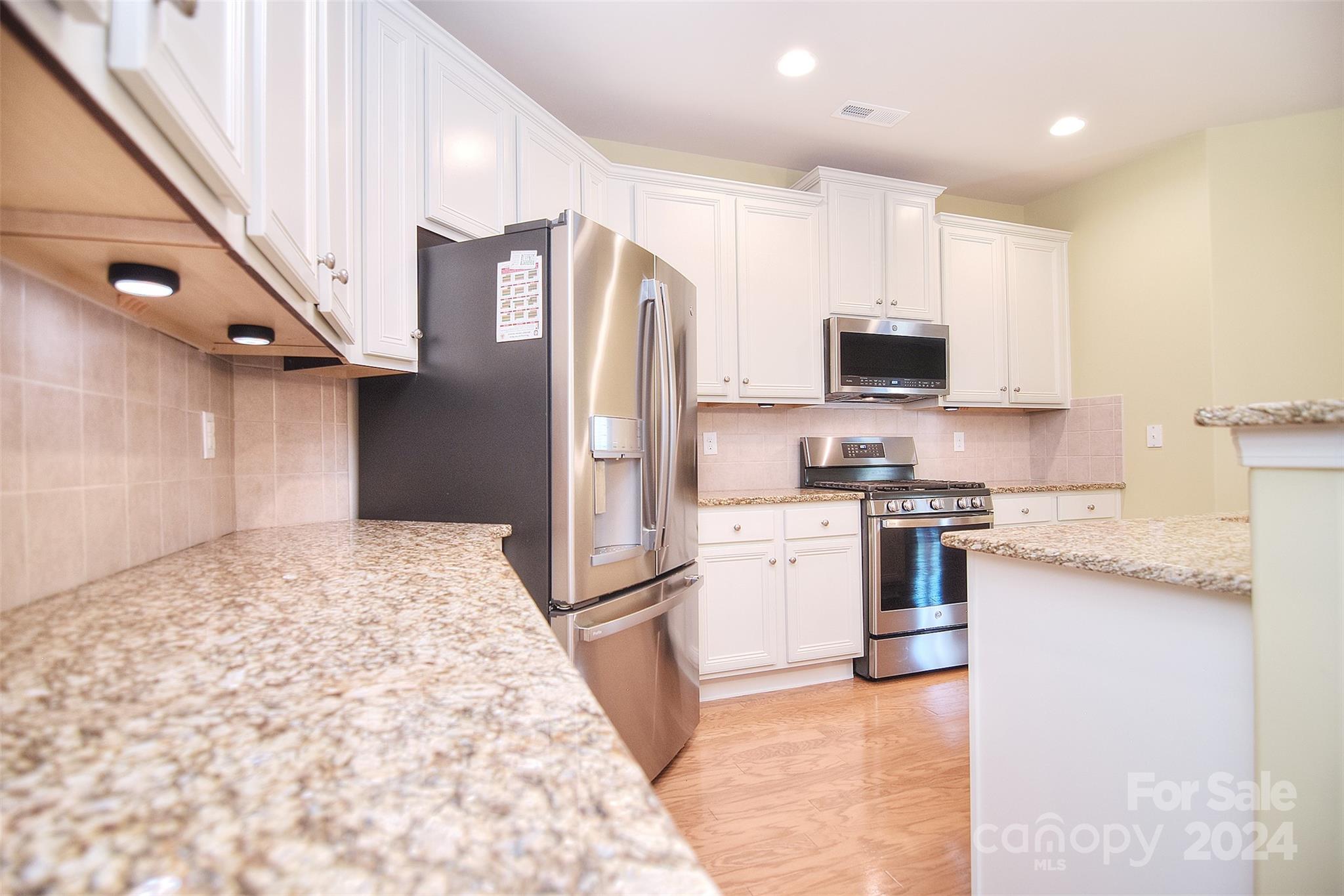 7004 Sedgewick Road Indian Trail, NC 28079 - Photo 10 of 38 a kitchen with stainless steel appliances granite countertop a refrigerator sink and stove