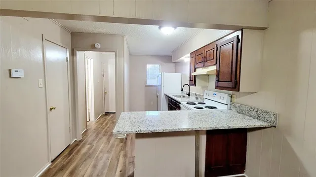 a kitchen with a sink and a wooden floor