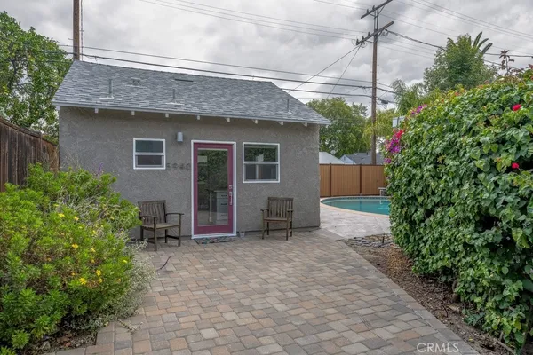 a view of a house with potted plants and a table and chairs