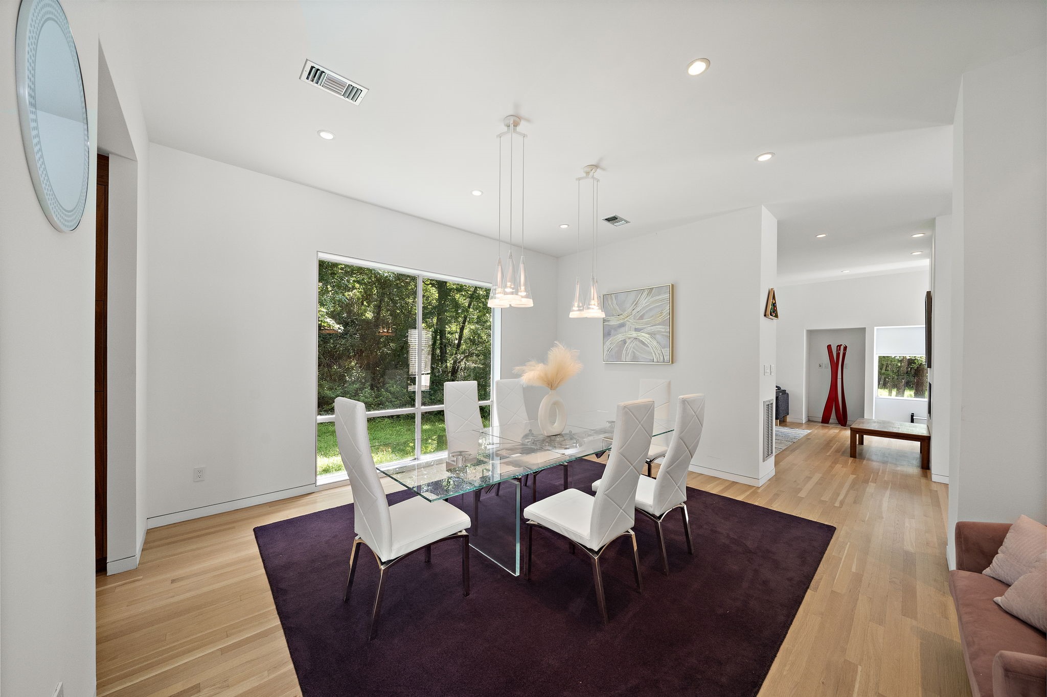 118 Angel Leaf Road The Woodlands, TX 77380 - Photo 13 of 50 Elegant dining area with statement lighting, modern furnishings, and open sightlines to the kitchen and stairway landing.
