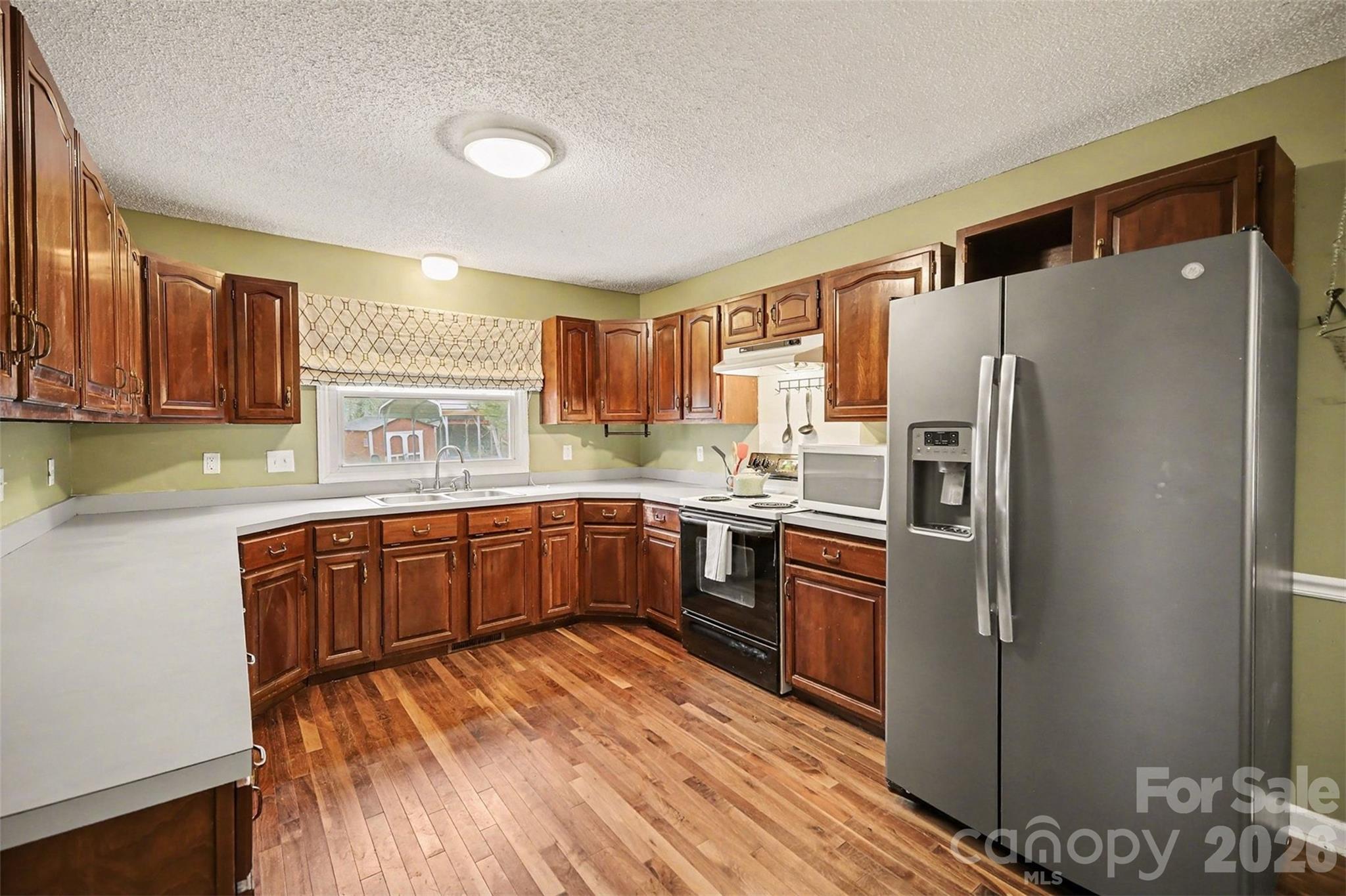 16421 Shallow Pond Road Charlotte, NC 28278 - Photo 10 of 24 a kitchen with stainless steel appliances granite countertop a refrigerator sink and wooden cabinets