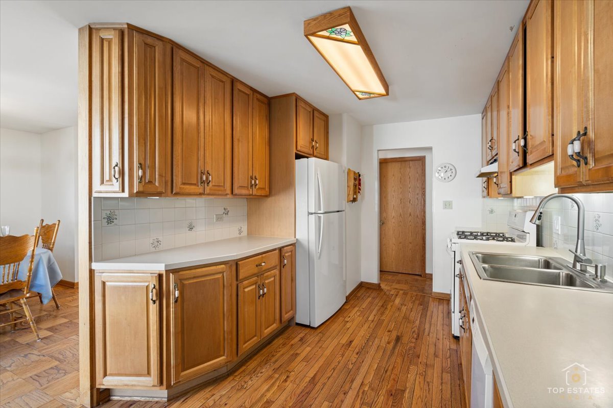 2302 Fulle Street Rolling Meadows, IL 60008 - Photo 20 of 48 a kitchen with stainless steel appliances granite countertop a refrigerator a sink dishwasher and wooden cabinets with wooden floor