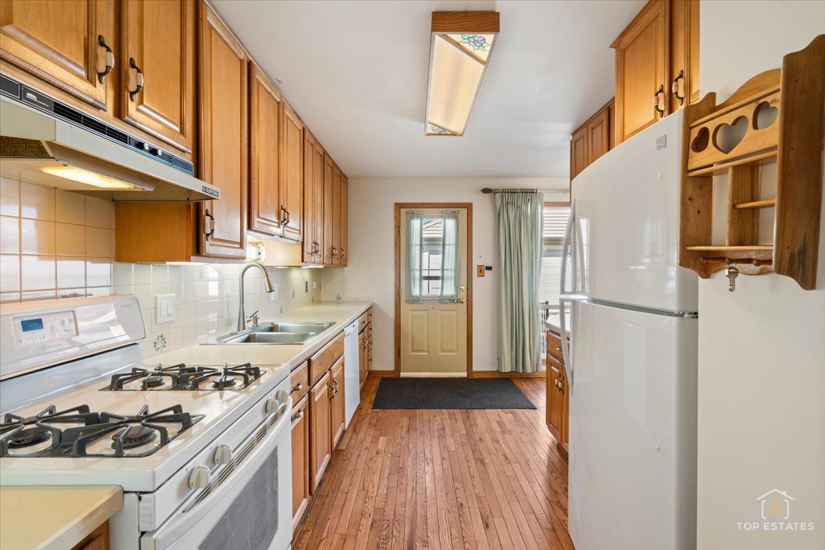 2302 Fulle Street Rolling Meadows, IL 60008 - Photo 21 of 48 a kitchen with stainless steel appliances a refrigerator a sink and wooden floors