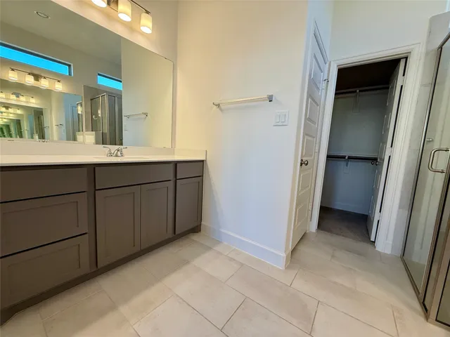 a spacious bathroom with a double vanity sink and a mirror