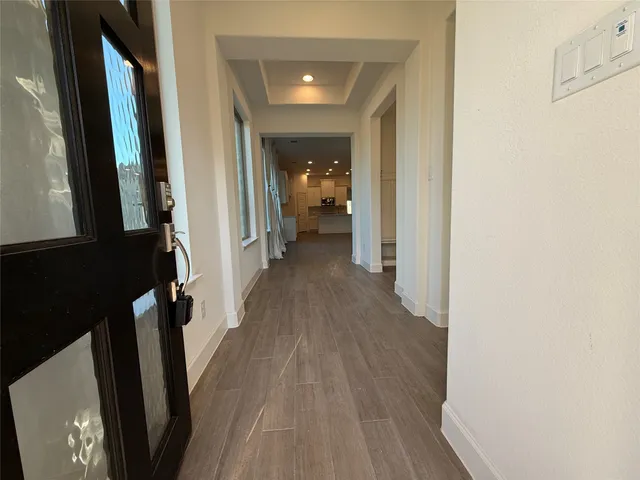 a view of a hallway with wooden floor