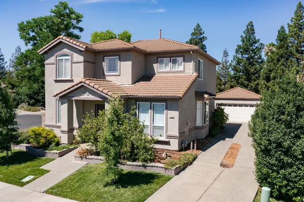 a front view of a house with a garden