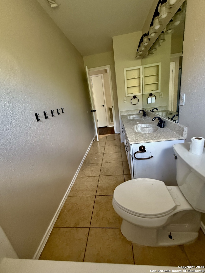 821 Dimrock Schertz, TX 78154 - Photo 14 of 20 a bathroom with a toilet sink and mirror