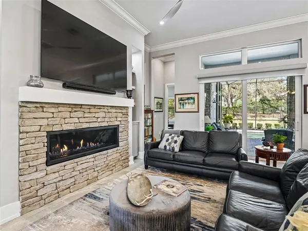 a dining room with stainless steel appliances kitchen island granite countertop a table chairs and a chandelier