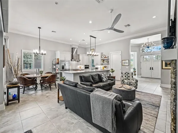 a kitchen with stainless steel appliances kitchen island granite countertop a refrigerator oven a sink a stove and chairs