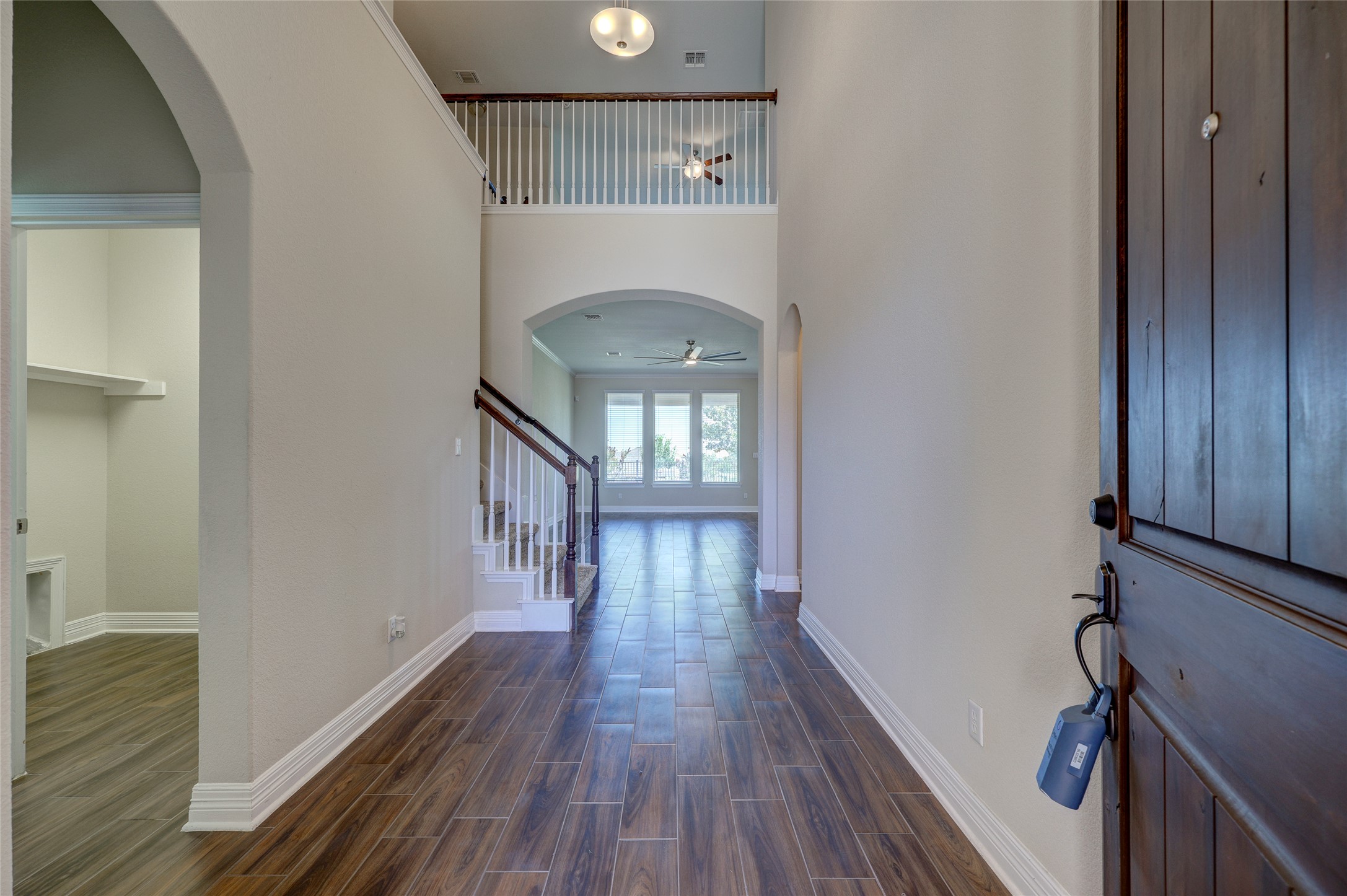 409 Betony Loop Buda, TX 78610 - Photo 4 of 38 A spacious foyer welcomes you with wood-look tile flooring and a view to the living area.