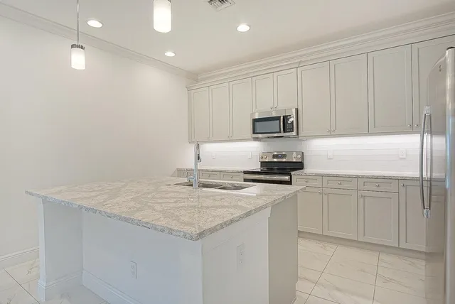 a kitchen with granite countertop white cabinets white stainless steel appliances and a sink