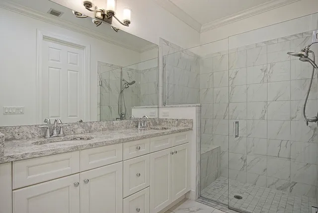 a bathroom with a granite countertop sink a mirror and shower