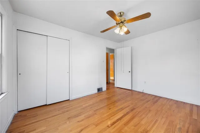 a view of a livingroom with a ceiling fan and wooden floor