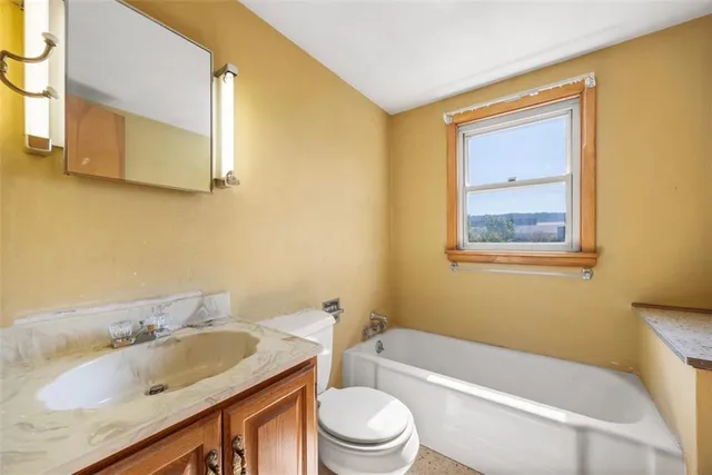 a bathroom with a granite countertop sink toilet and mirror