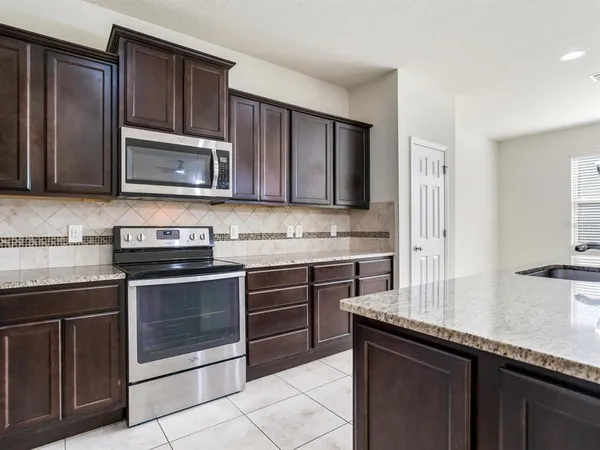 a kitchen with granite countertop wooden cabinets and stainless steel appliances