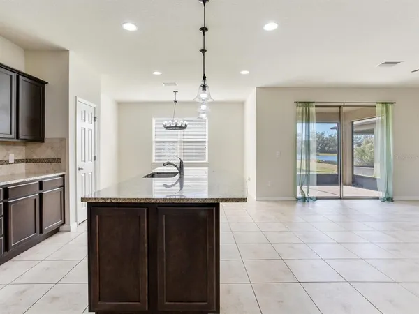 a kitchen with granite countertop a sink a stove and cabinets
