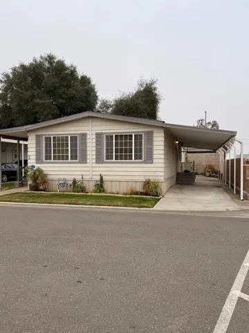 front view of house with a yard and potted plants