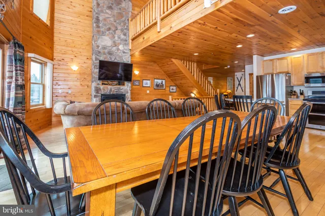 a outdoor living space with furniture a flat screen tv and a fireplace