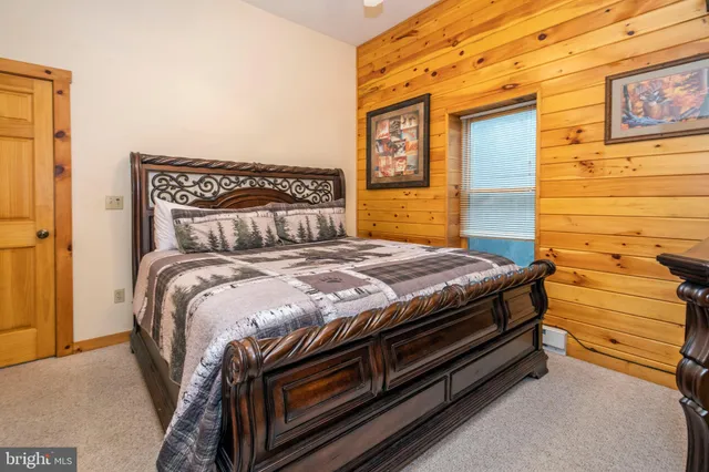 a bedroom with a bed and a flat tv screen on dresser