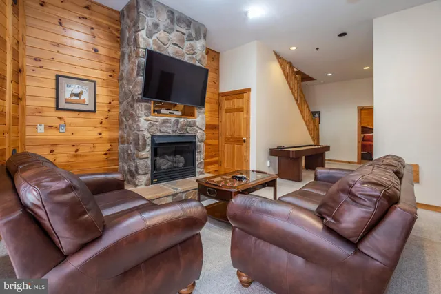 a living room with furniture a flat screen tv and a fireplace