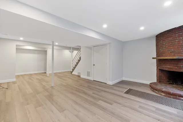 a view of empty room with wooden floor and fireplace