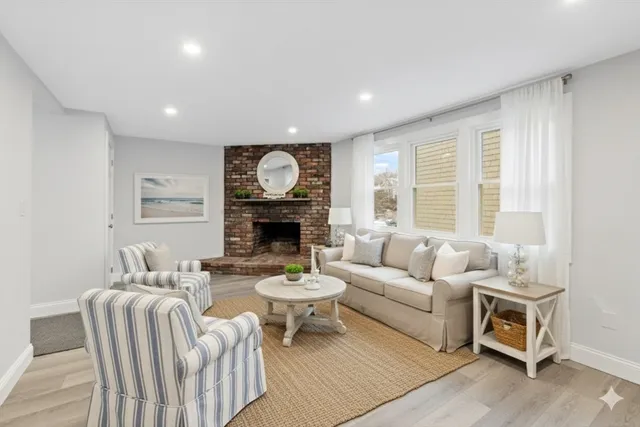 a living room with furniture a fireplace and a large window