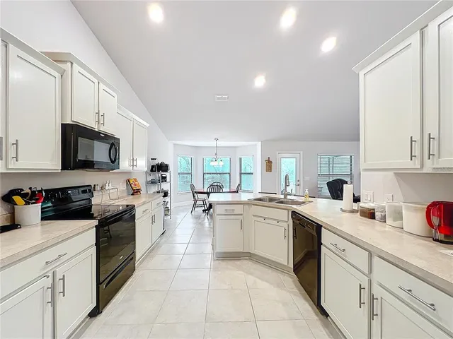 a kitchen with a sink a stove top oven and cabinets