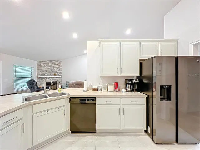 a kitchen with white cabinets and refrigerator