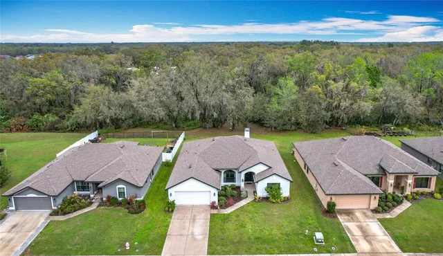 an aerial view of a house with swimming pool garden and outdoor seating