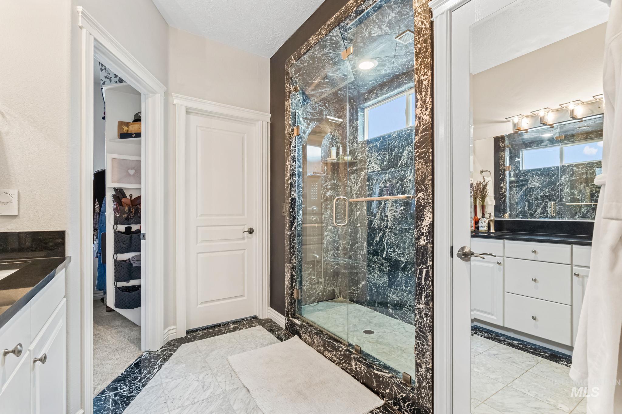4235 Trekker Rim Drive East Boise, ID 83716 - Photo 16 of 33 Bathroom featuring vanity, a marble finish shower, and a spacious closet