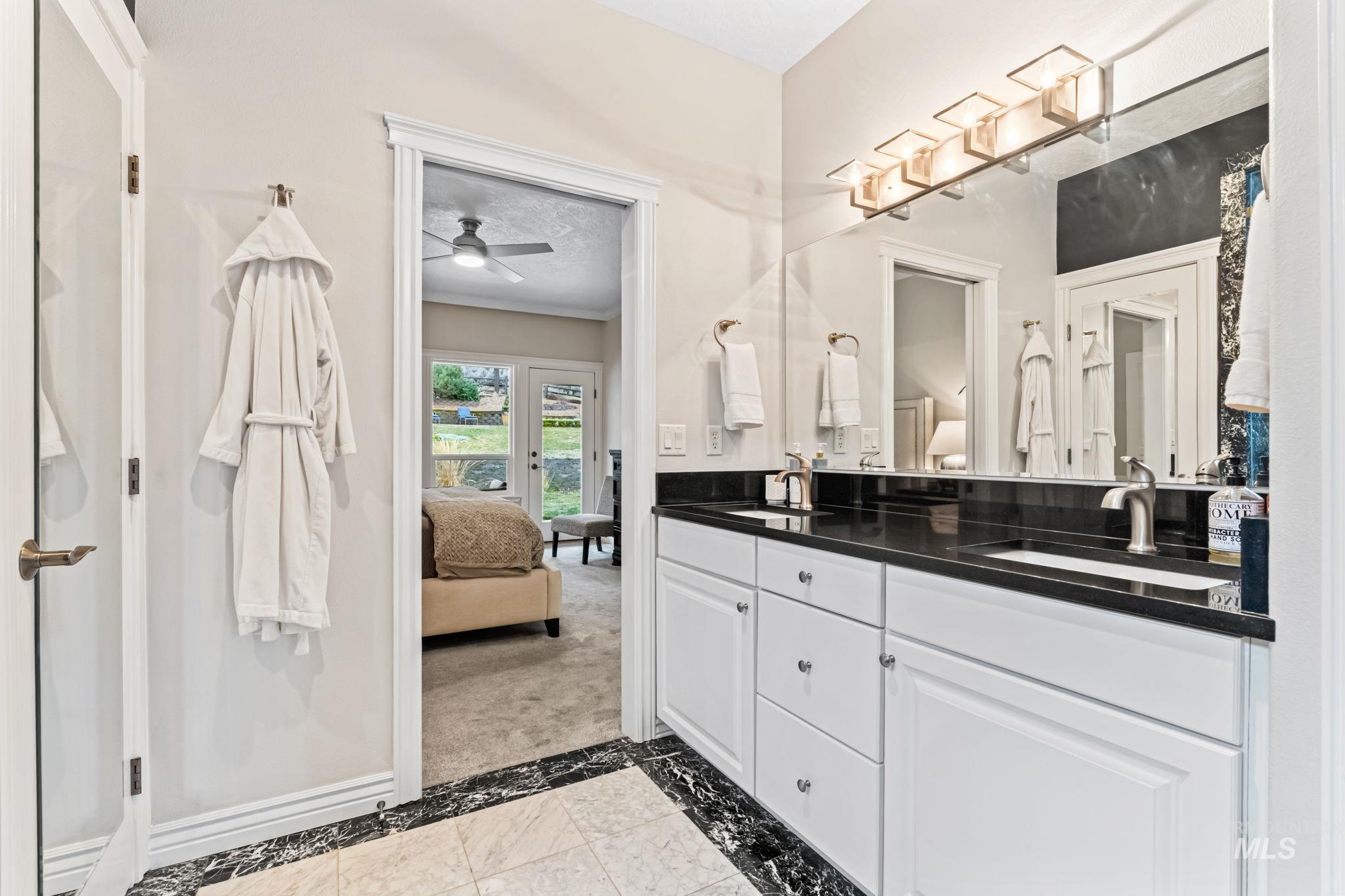 4235 Trekker Rim Drive East Boise, ID 83716 - Photo 17 of 33 Ensuite bathroom with double vanity, inlaid floor details, and ceiling fan