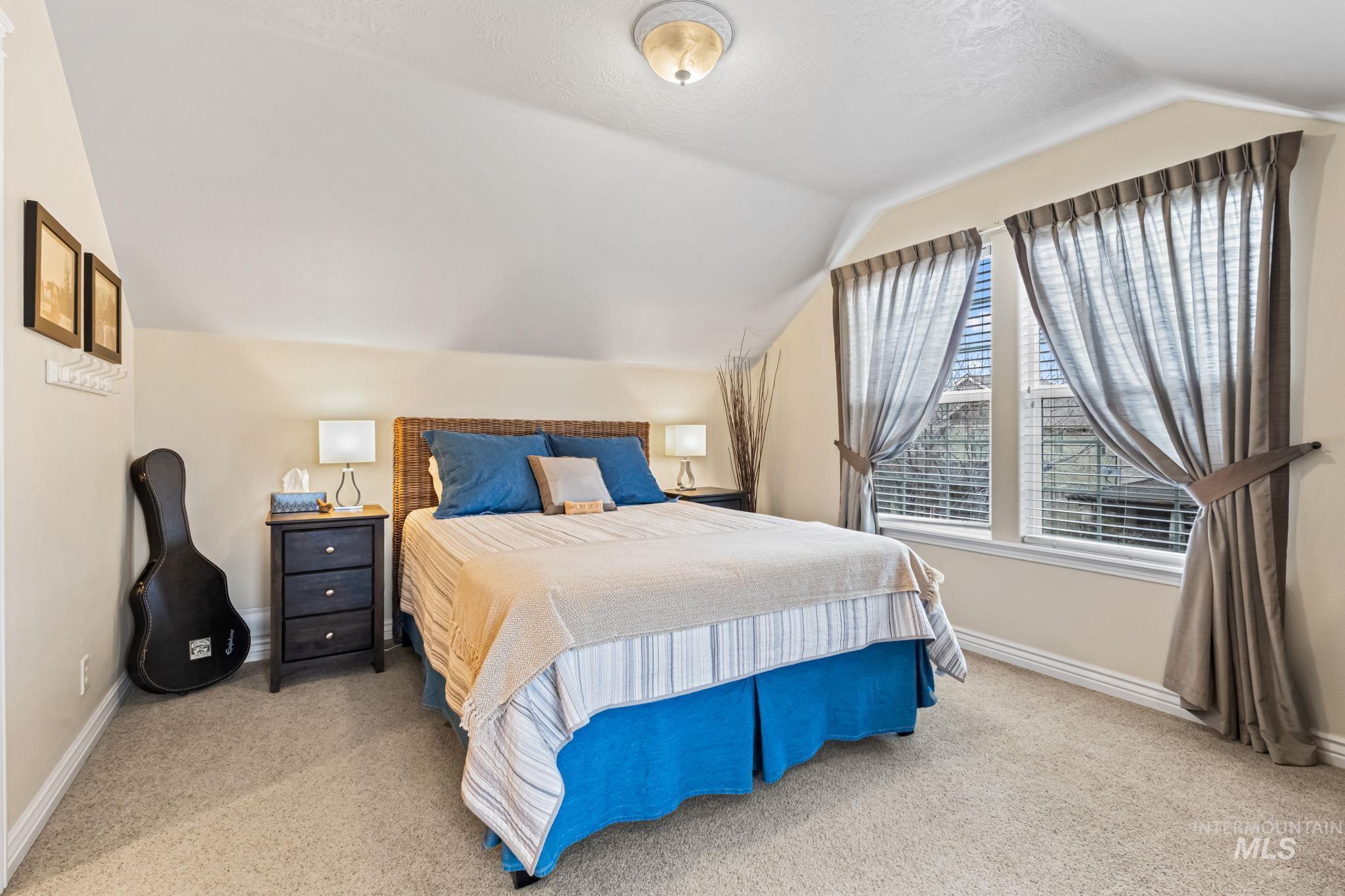4235 Trekker Rim Drive East Boise, ID 83716 - Photo 21 of 33 Bedroom featuring lofted ceiling, light colored carpet, and a textured ceiling