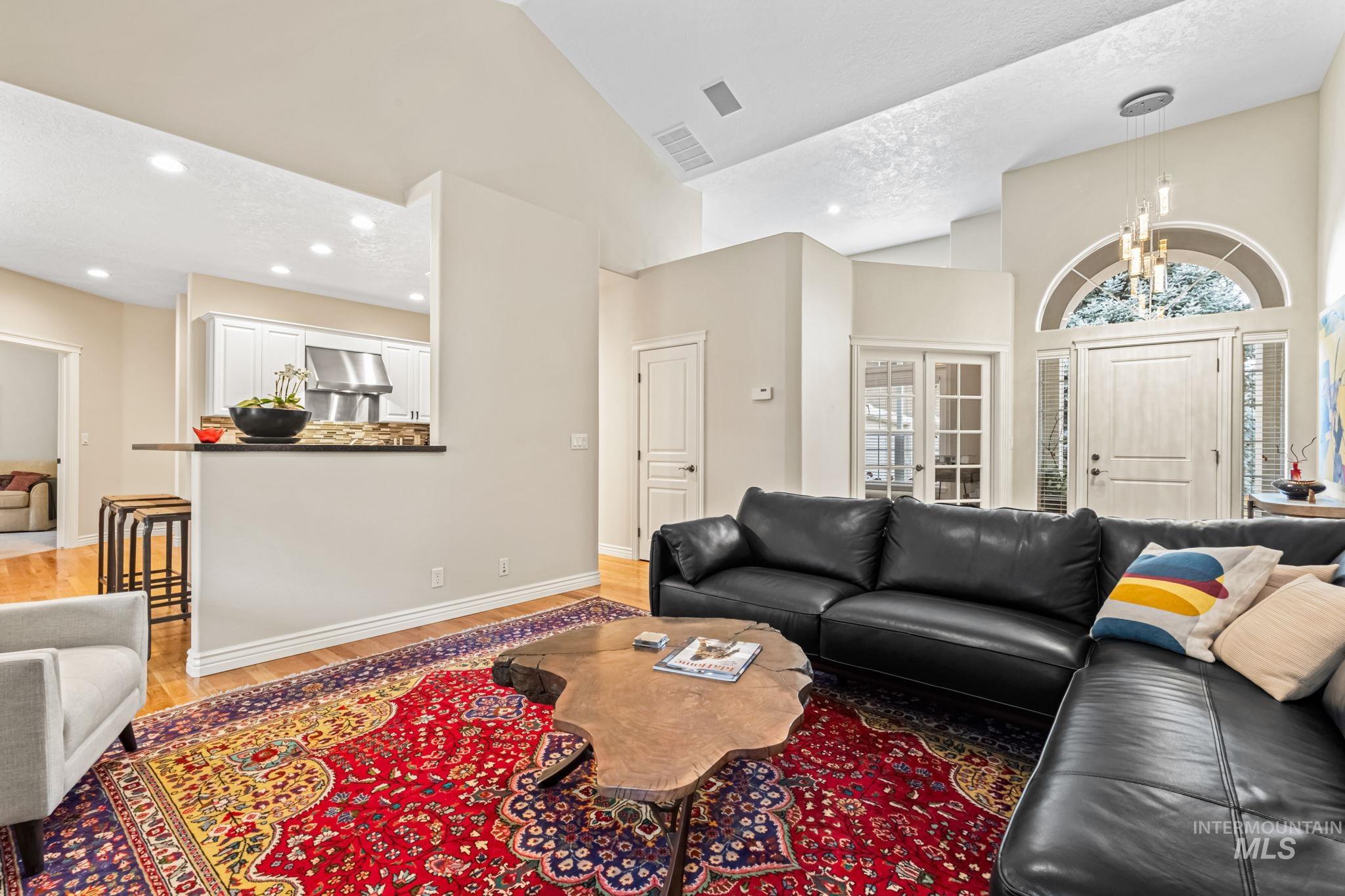 4235 Trekker Rim Drive East Boise, ID 83716 - Photo 7 of 33 Living room with light wood-style flooring, high vaulted ceiling, a chandelier, and recessed lighting