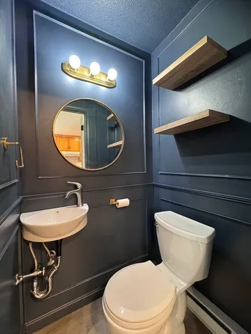 a bathroom with a toilet sink and mirror