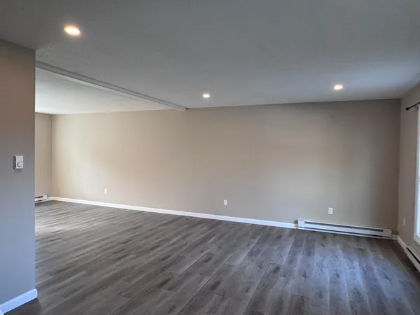 a view of an empty room with wooden floor
